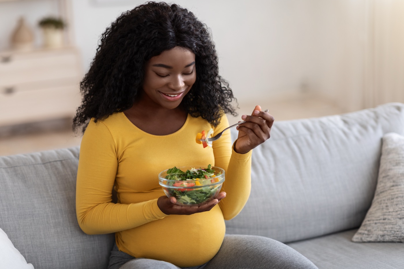 Smiling pregnant woman enjoying healthy food, copy space