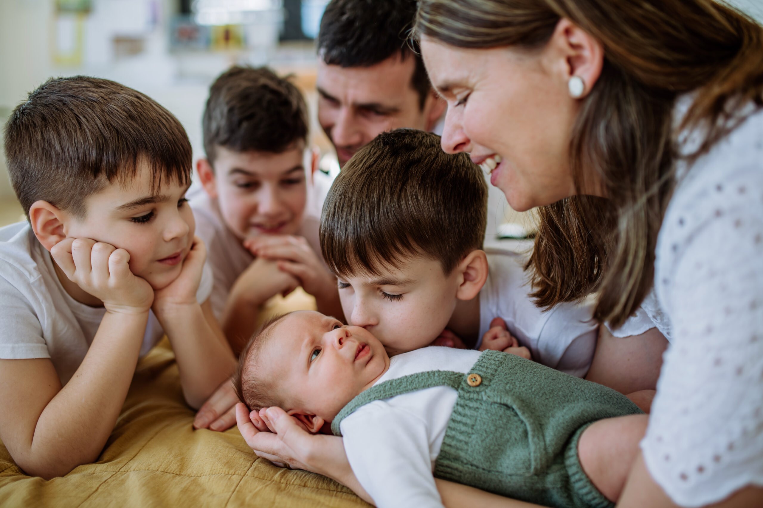 Big family with four kids enjoying their newborn baby.